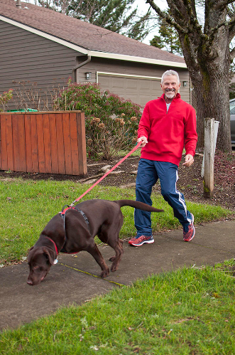 Michael G in a red sweater with his dog Rufus