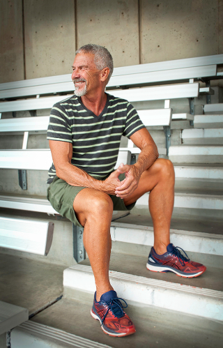 Michael G in a striped shirt on the bleachers