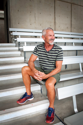 Michael G in a striped shirt on the bleachers
